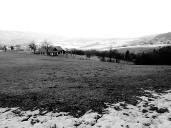 Scenic view of snowcapped field against sky