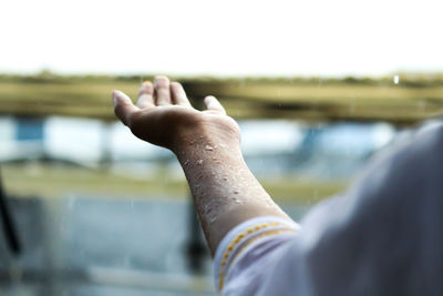 Rain falling on hands of woman