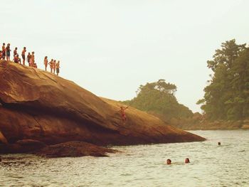 People at beach against clear sky