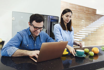 Friends using laptop at home