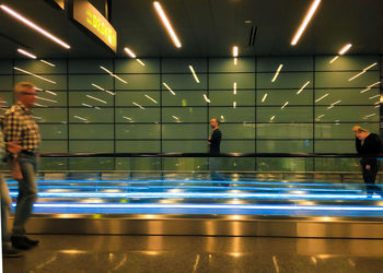 People standing in illuminated underground lights