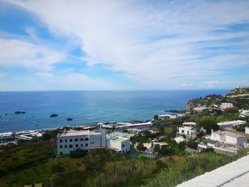 High angle view of townscape by sea against sky