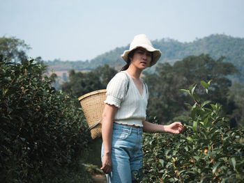 Full length of young woman standing in farm