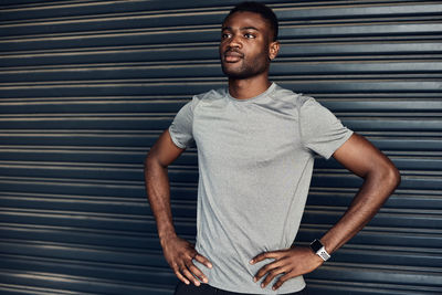 Portrait of young man standing against wall