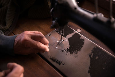 Close-up of person hands working on sewing machine