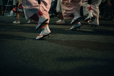 Low section of people dancing in traditional shoes on road
