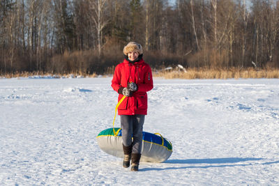 Portrait of young man standing on snow covered field