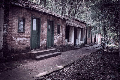 Abandoned building by trees in city