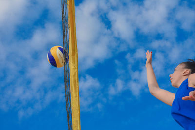 Low angle view of woman playing volleyball