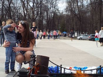 Mother crouching by son on walkway