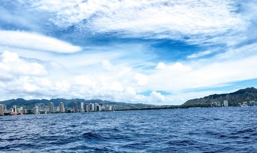 Scenic view of sea by buildings against sky