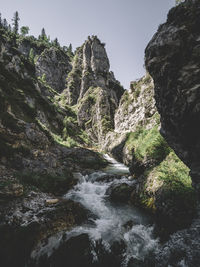 Scenic view of waterfall in forest against clear sky