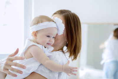 Woman holding baby girl at home