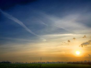 Scenic view of field against sky at sunset