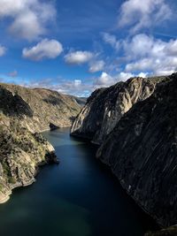 Scenic view of river amidst mountains against sky