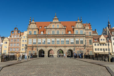 Buildings in city against clear blue sky