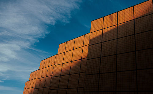 Low angle view of modern geometric building against sky