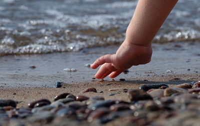 Close-up of child touching beach sand