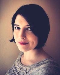 Portrait of smiling woman against wall