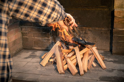 Man preparing barbecue grill with a burning wood pyre. male cooking meat on bbq fire in a summer day