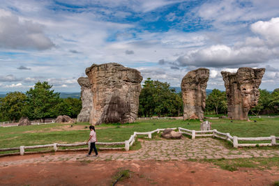 Tourists at historical building against cloudy sky