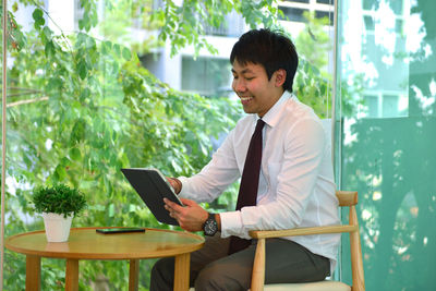 Businessman using digital tablet at table in office