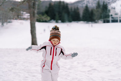 Full length of woman skiing on snow covered field