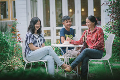 Women sitting on chair at plants