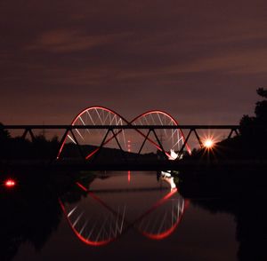 Silhouette bridge against sky at night