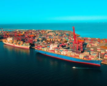 High angle view of commercial dock by sea against sky