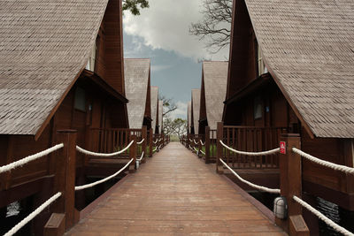 Footbridge amidst buildings against sky