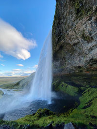 Scenic view of waterfall island travel destination holiday blue sky cloud water cliff view point 