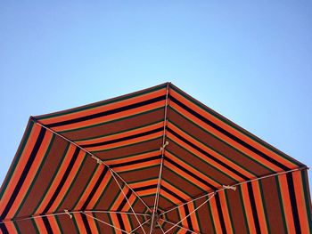 Low angle view of beach umbrella against clear blue sky