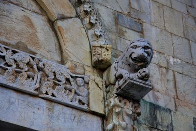 Low angle view of old statue against building