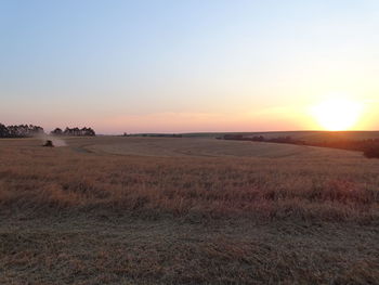 Scenic view of field against clear sky during sunset