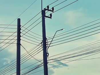 Low angle view of electricity pylon against sky