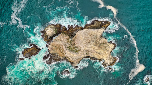 High angle view of rocks on sea shore