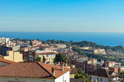 High angle view of townscape by sea against sky