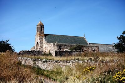 Low angle view of old building against clear blue sky