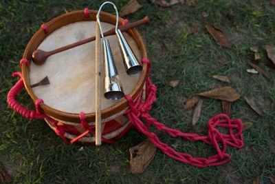 Cow bell and handmade colorfull drum laying on the grass