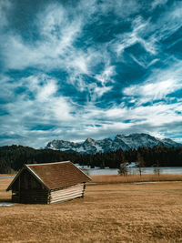 Houses on field by mountain against sky