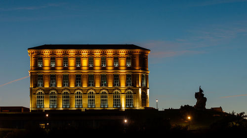 Low angle view of illuminated buildings against sky at night