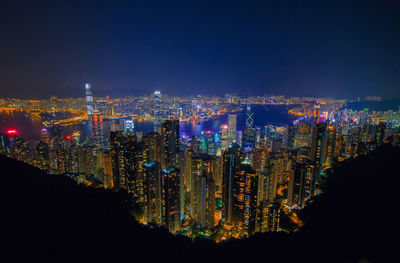 Illuminated buildings against sky at night