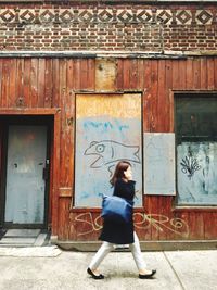 Full length of woman standing against building