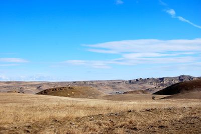 Scenic view of desert against blue sky