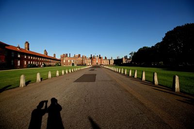 Shadow of people on built structure against clear sky