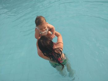 High angle view of mother and son swimming in pool