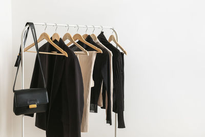 Modern rack with capsule collection in neutral black and beige colours. 