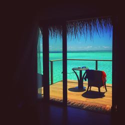 Chairs on beach against window