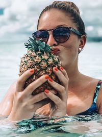 Midsection of man holding ice cream in swimming pool